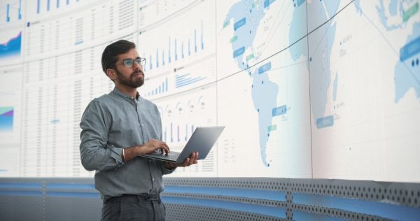 Male Logistics Expert Holding Laptop Computer And Analyzing