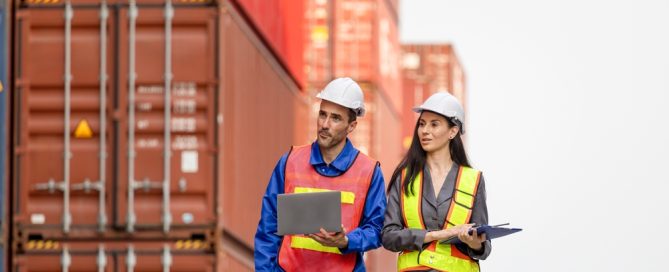 Engineers Inspecting Shipping Containers At Port Terminal